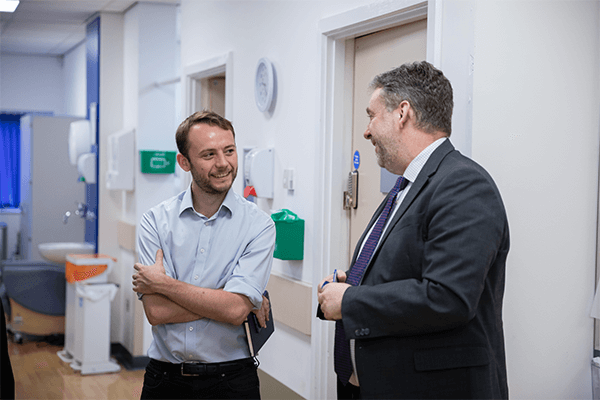 two men in conversation smiling