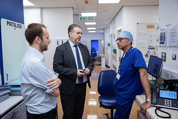 three men in conversation in a hospital