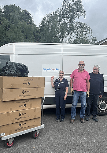 smiling people in front of van and boxes