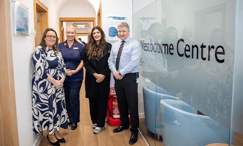 four people smiling in hospital