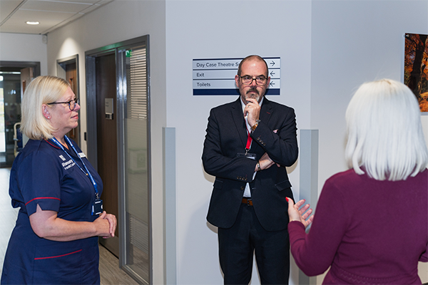 man and two women talking in a hospital