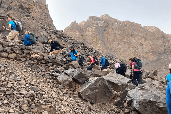 school group hiking across rocks