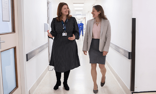 two women talking and walking