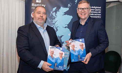 two men smiling holding reports