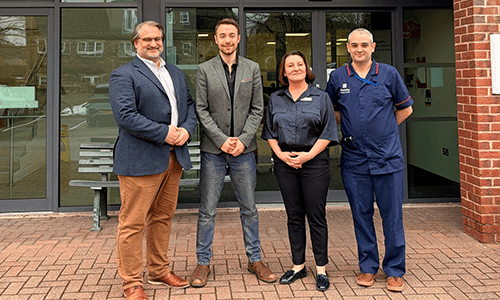 four people smiling outside